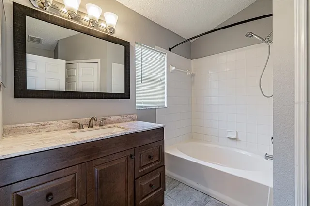 a bathroom with a tub a sink and mirror