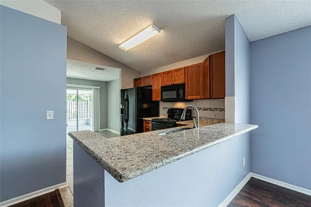 a kitchen with granite countertop kitchen island a sink appliances and cabinets