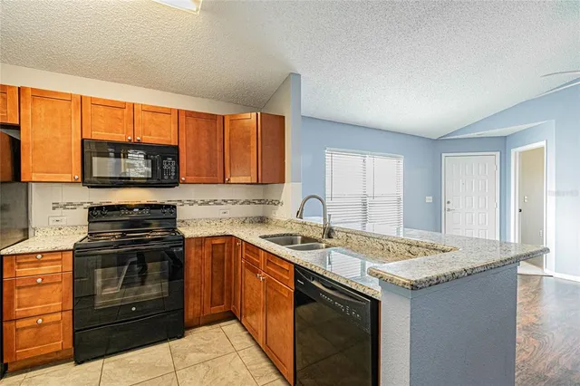 a kitchen with stainless steel appliances granite countertop a sink stove and microwave