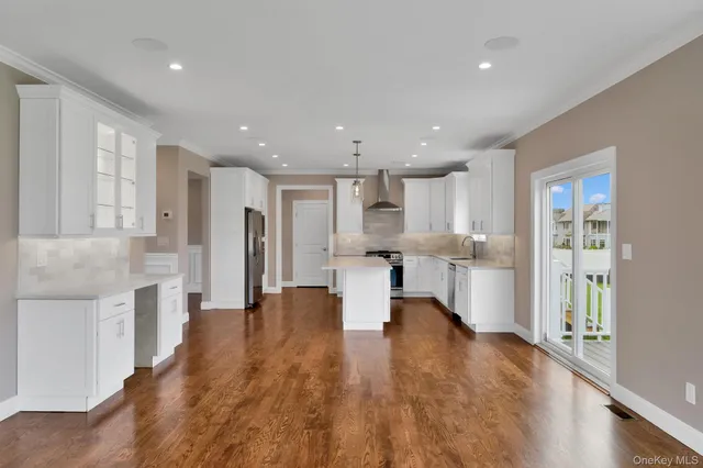 a view of kitchen with refrigerator stove and wooden floor