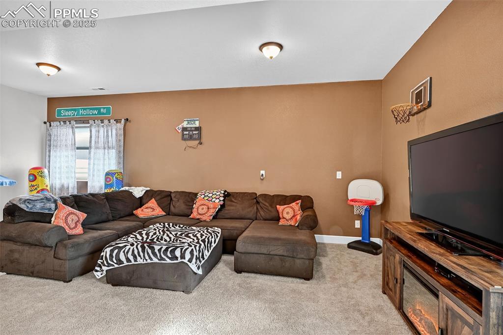 19125 Baskerville Way Monument, CO 80132 - Photo 34 of 39 a living room with furniture and a flat screen tv
