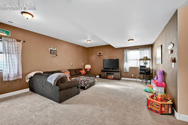a living room with furniture a flat screen tv and a window