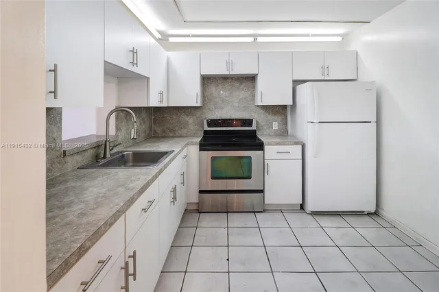 a kitchen with a stove a sink and a refrigerator