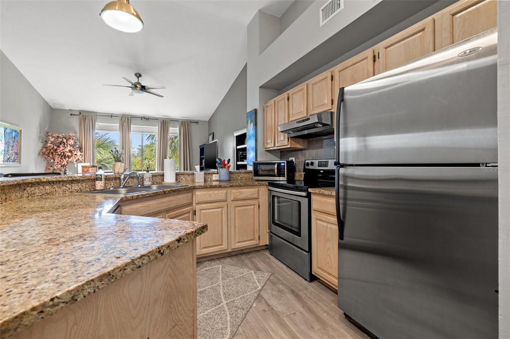 1039 Normandy Trace Road, Unit 1039 Tampa, FL 33602 - Photo 10 of 19 a kitchen with granite countertop a sink stainless steel appliances and cabinets
