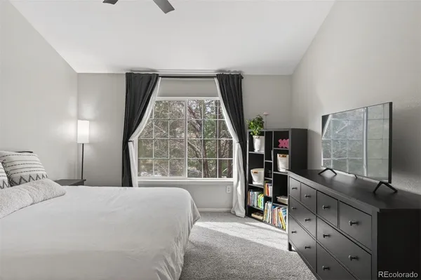 a bedroom with a large bed and a flat tv screen on dresser