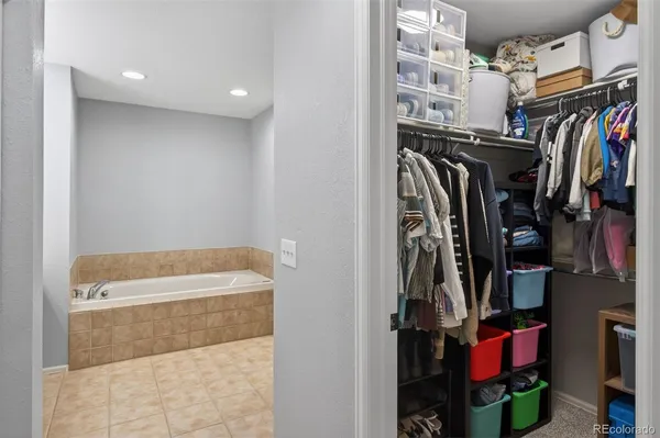 a view of walk in closet with clothes and shoes