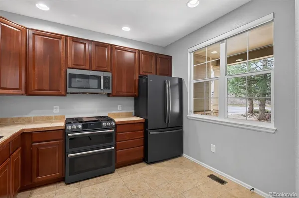a kitchen with stainless steel appliances granite countertop a refrigerator stove and microwave