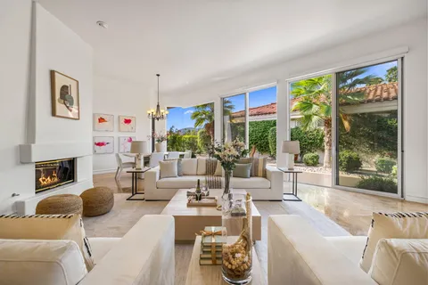 a very nice looking living room with a large window and dining table