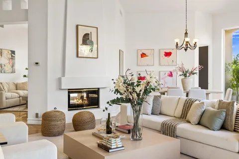 a living room with furniture a clock and a fireplace