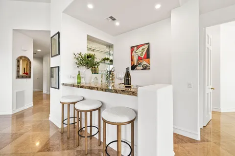 a kitchen with stainless steel appliances granite countertop a stove top oven a sink dishwasher a dining table and chairs with wooden floor