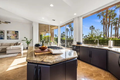 a living room with furniture a rug and a floor to ceiling window