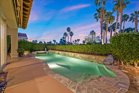 a patio with a table and chairs and potted plants