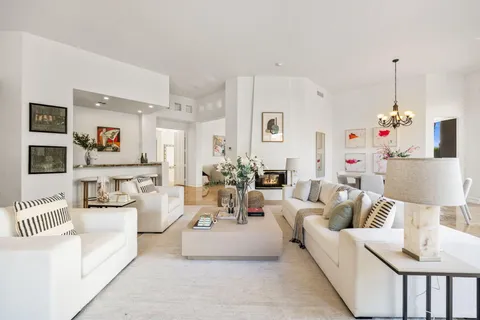 a dining room with wooden floor a chandelier a wooden table and chairs