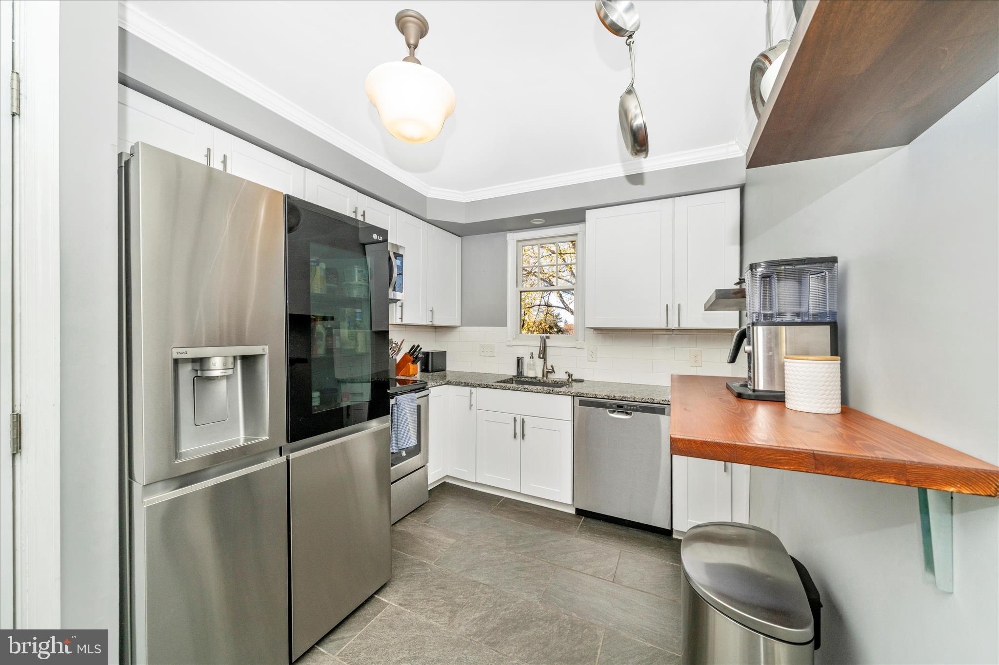 313 North Market Street Frederick, MD 21701 - Photo 12 of 40 a kitchen with a sink stainless steel appliances a counter top space cabinets and a window