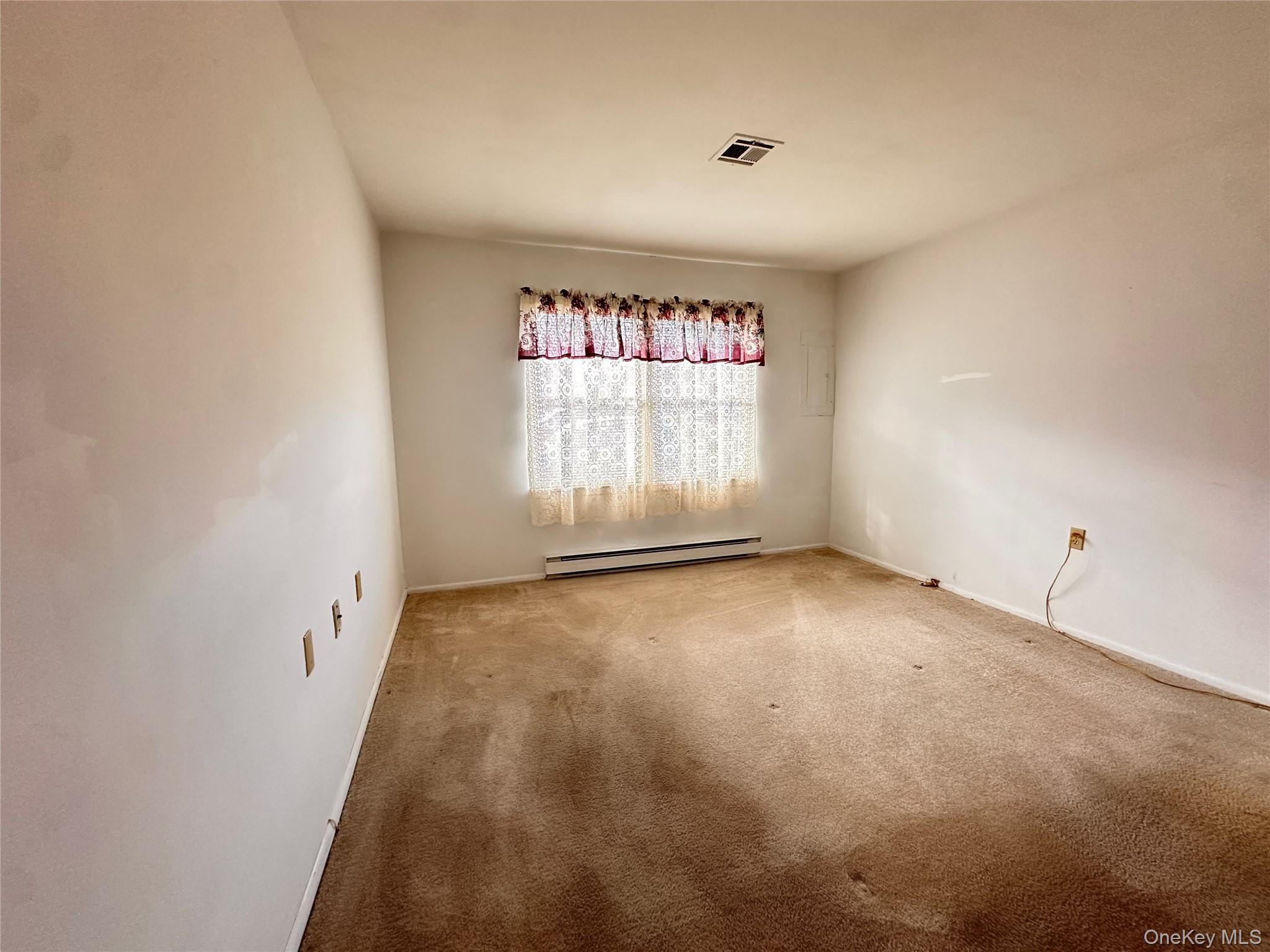 169 Ventry Court, Unit A Ridge, NY 11961 - Photo 12 of 17 an empty room with a window