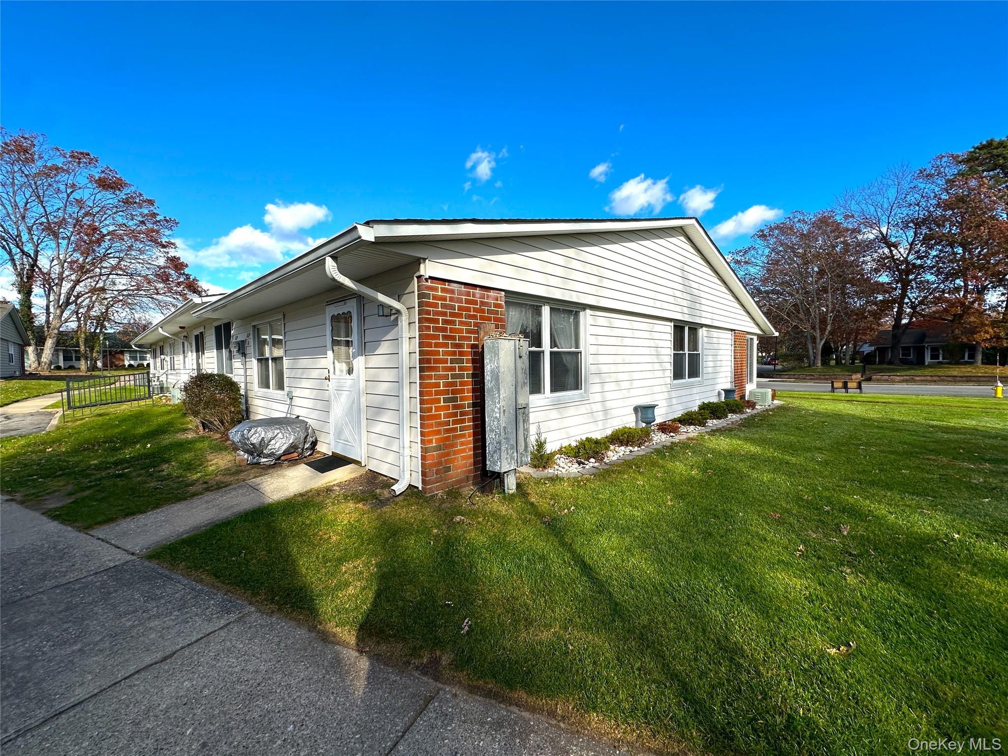 169 Ventry Court, Unit A Ridge, NY 11961 - Photo 3 of 17 a front view of house with yard and green space