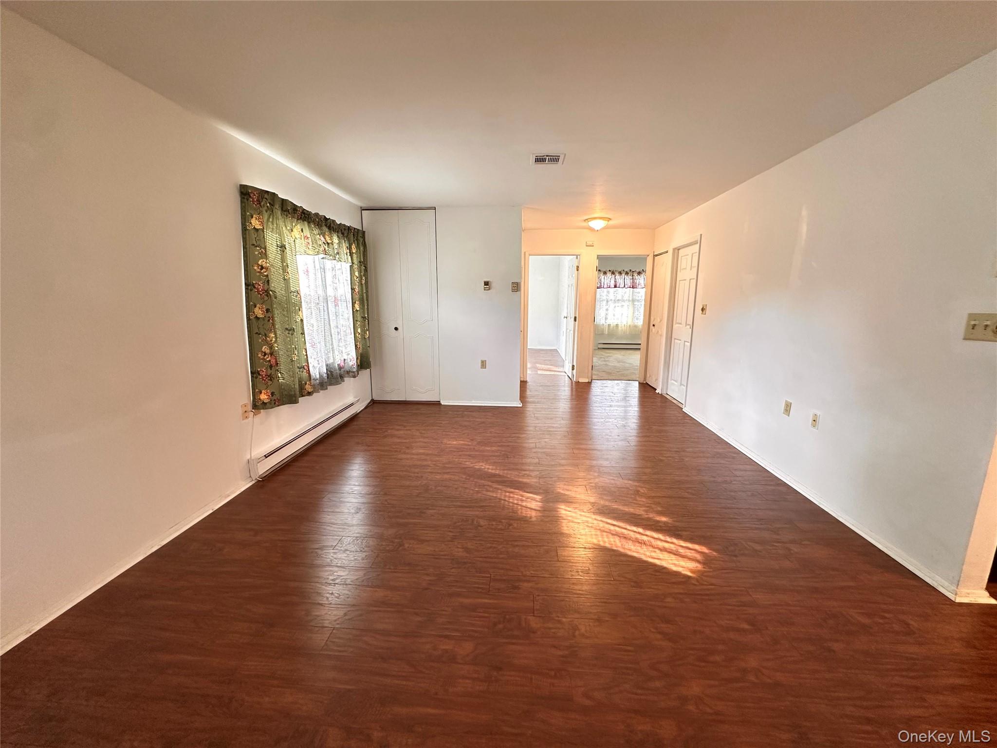 169 Ventry Court, Unit A Ridge, NY 11961 - Photo 5 of 17 wooden floor in an empty room with a window