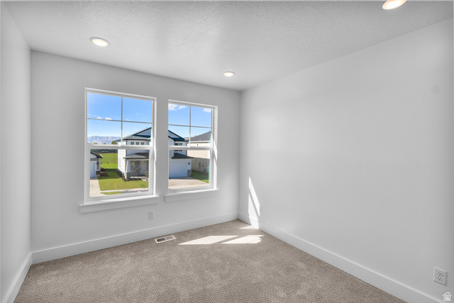 1213 West 500 South Logan, UT 84321 - Photo 18 of 29 Bright room featuring two large grid-pattern windows, recessed lighting, neutral carpeting, and white baseboards