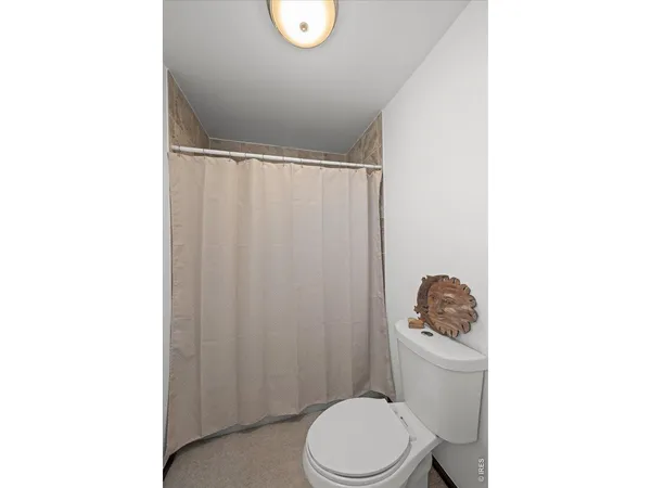 a white toilet sitting next to a shower curtain