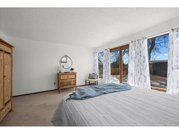 a bedroom with a bed and a flat tv screen on dresser