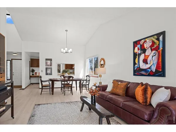 a living room with furniture a dining table and a wooden floor