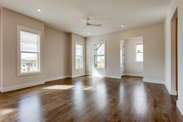 an empty room with wooden floor and windows