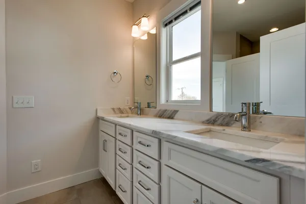 a bathroom with a granite countertop sink and a mirror