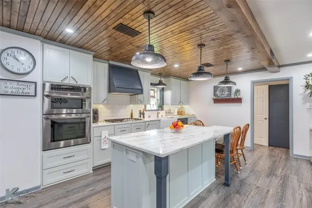 a kitchen with a stove cabinets and wooden floor