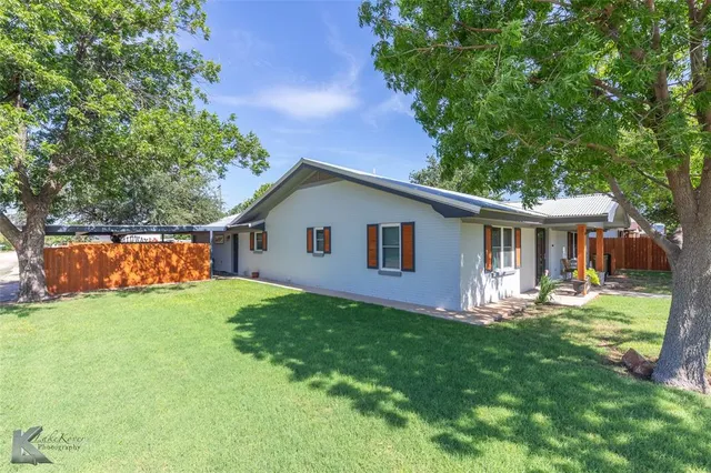 a front view of house with a garden and trees