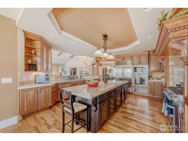 a kitchen with kitchen island a dining table chairs cabinets and stainless steel appliances