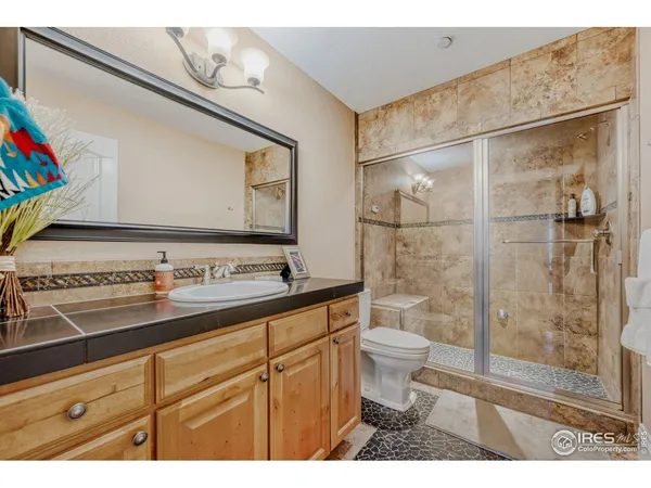 a open kitchen with stainless steel appliances kitchen island granite countertop a refrigerator a stove a sink dishwasher and white cabinets with wooden floor