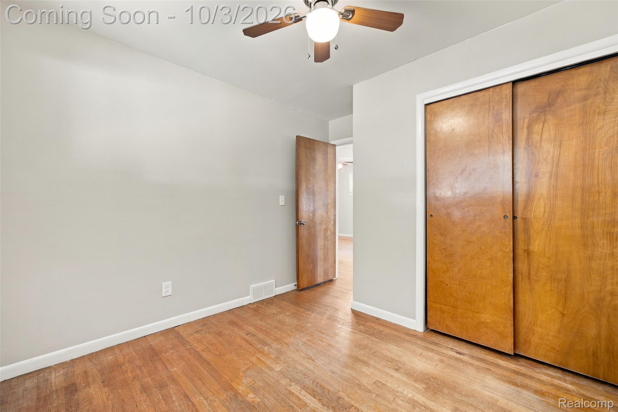 556 Henry Ruff Road Garden City, MI 48135 - Photo 22 of 49 Hardwood flooring, neutral wall tones, wood-paneled sliding closet doors, wood-finish ceiling fan, and solid wood interior door