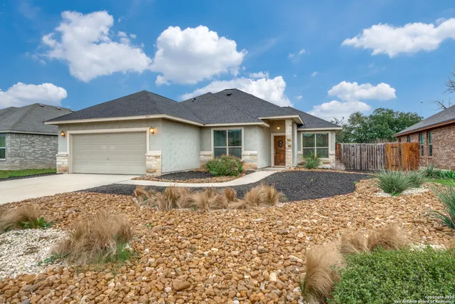 a view of a house with a yard and large tree