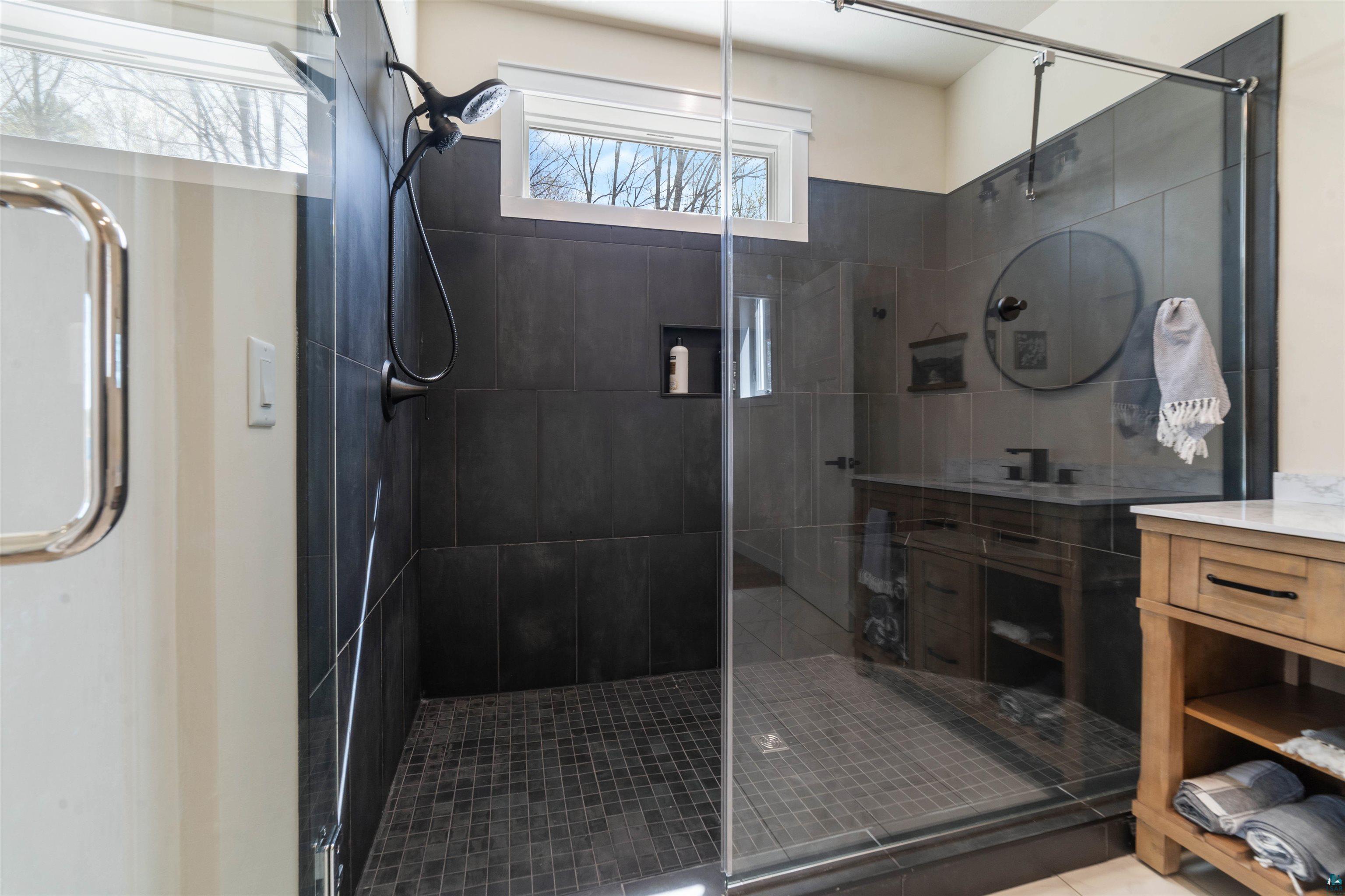 2000 West Chub Lake Road Carlton, MN 55718 - Photo 12 of 30 Spacious shower enclosure with dark large-format wall tiles and a contrasting mosaic tile floor