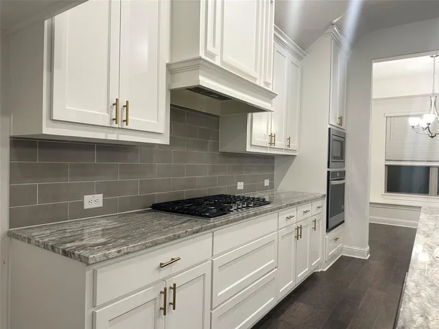 a kitchen with stainless steel appliances granite countertop a sink and a stove