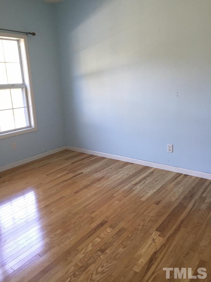 1150 Robertson Road Roxboro, NC 27574 - Photo 8 of 21 an empty room with wooden floor and windows