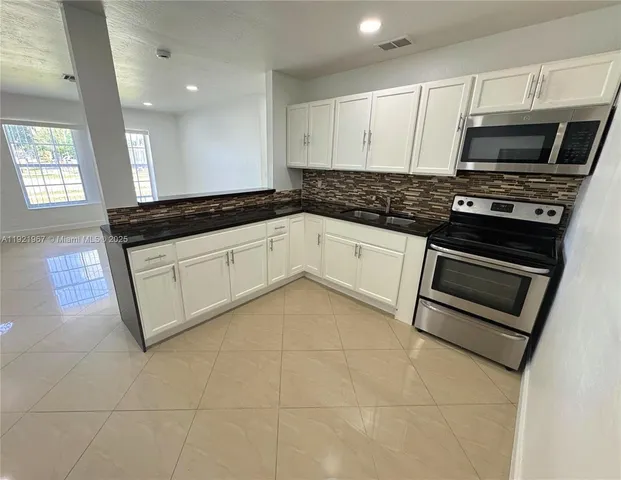a kitchen with stainless steel appliances granite countertop a sink and a stove