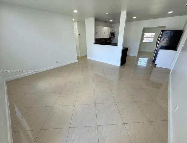 a view of a big room with kitchen and windows
