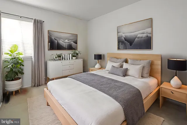 a bedroom with a bed and a painting on the wall