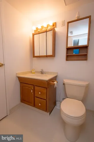 a bathroom with a toilet a sink and mirror