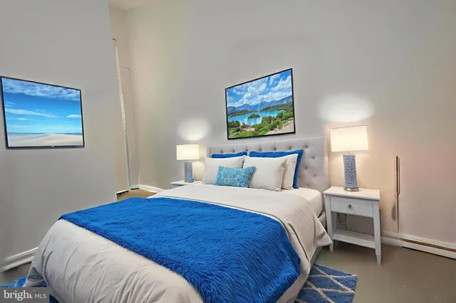 a bedroom with bed and a painting on the wall