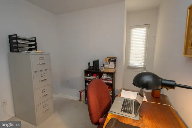 a view of a workspace with furniture and a window