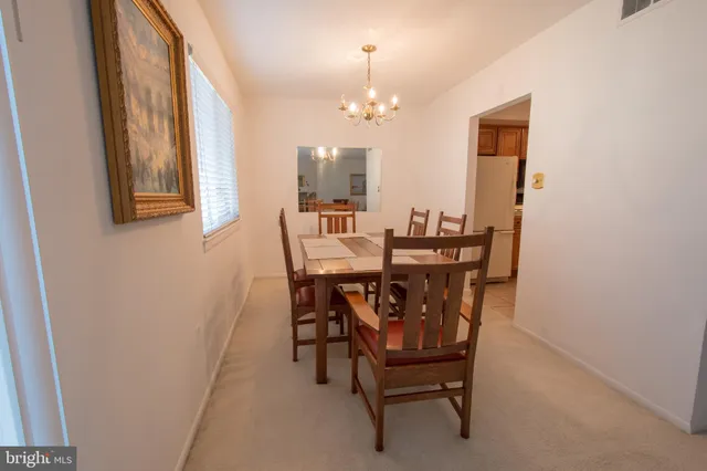 a view of a dining room with furniture and a chandelier