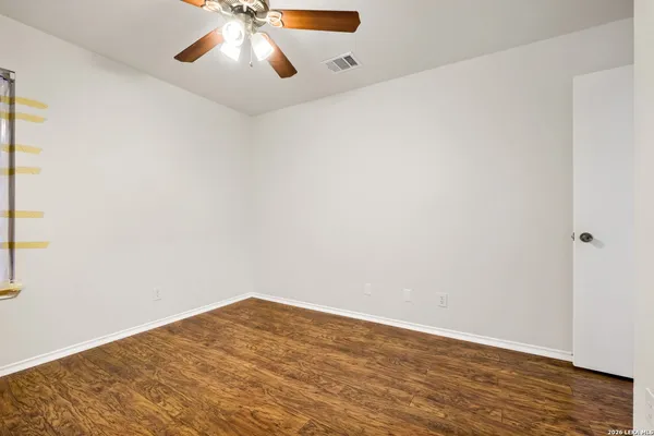 a view of an empty room with wooden floor