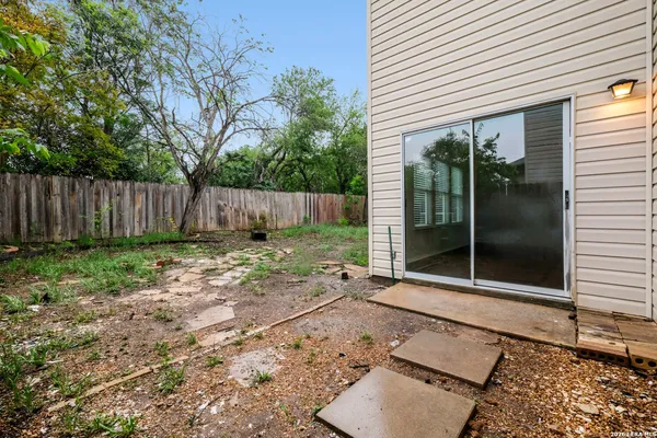 a view of a house with backyard and wooden fence