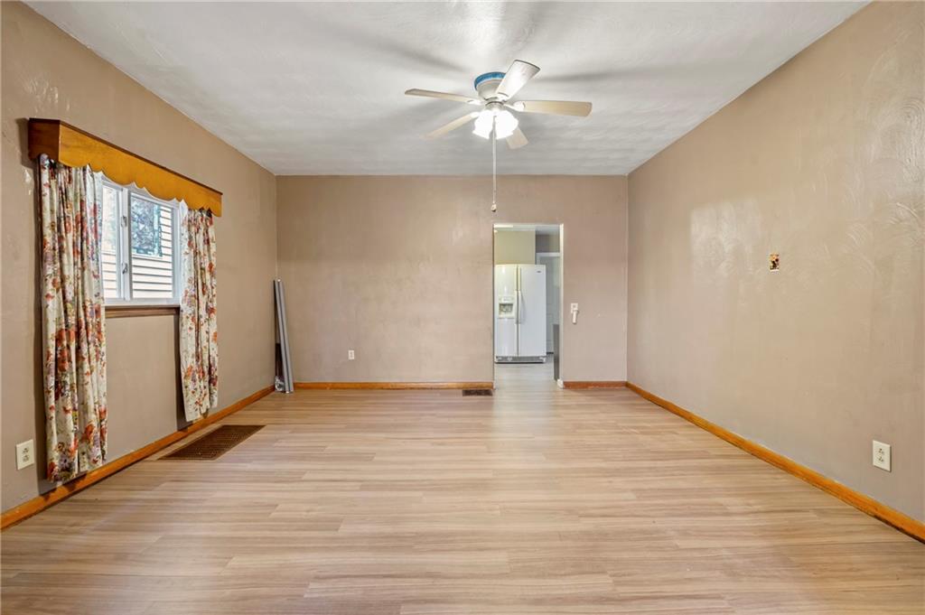 723 Freeport Road Creighton, PA 15030 - Photo 18 of 27 an empty room with wooden floor chandelier fan and windows