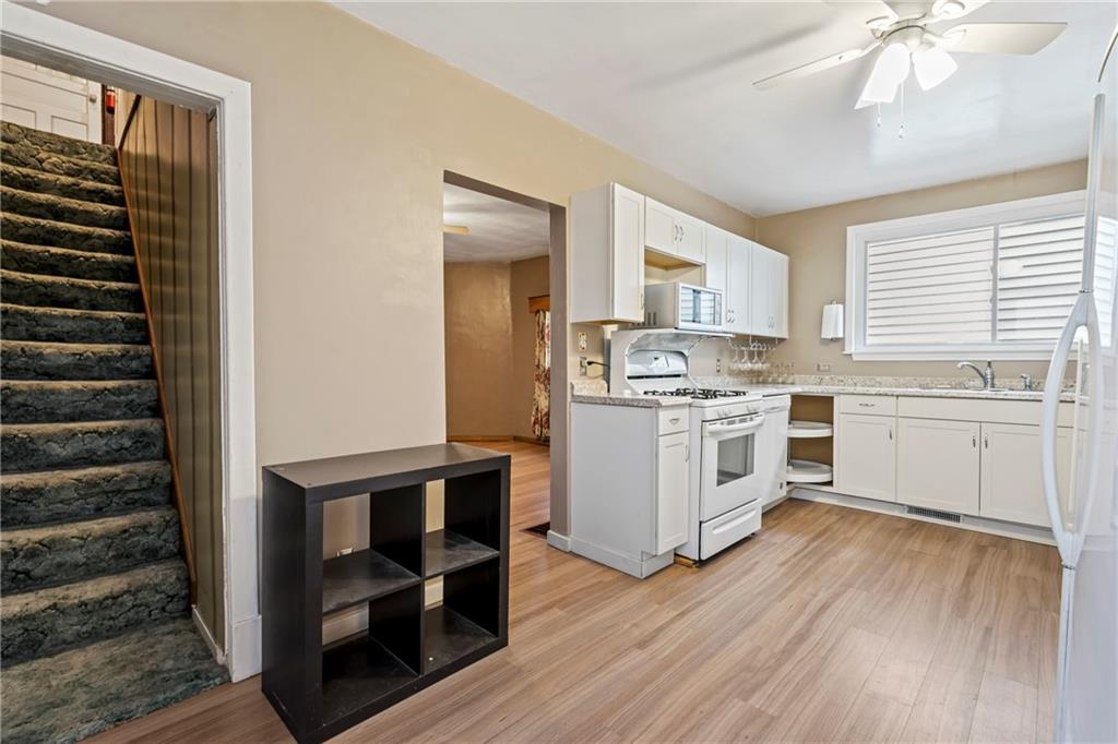 723 Freeport Road Creighton, PA 15030 - Photo 20 of 27 a kitchen with a stove cabinets and a wooden floor