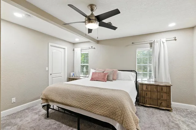 a bedroom with a bed a window and a chandelier