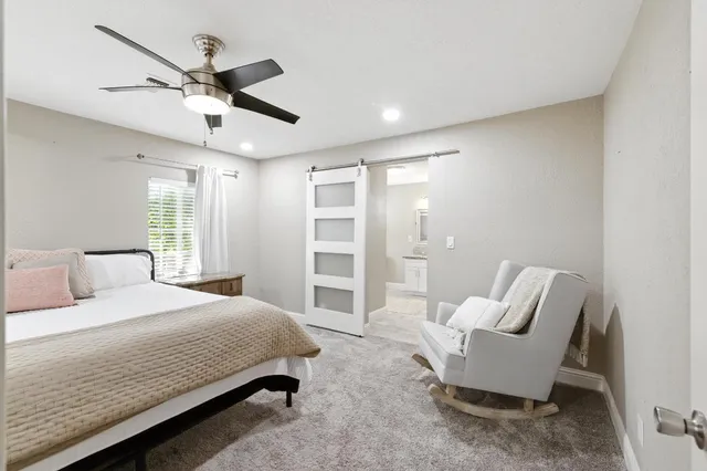 a bedroom with a bed a chair and window