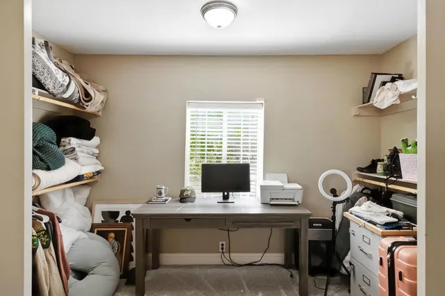 a view of a workspace with furniture and a window